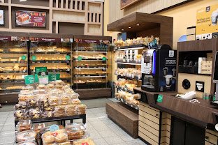 Upscale bakery and deli section with breads, pastries and a coffee bar at Auto Mercado in Herradura
