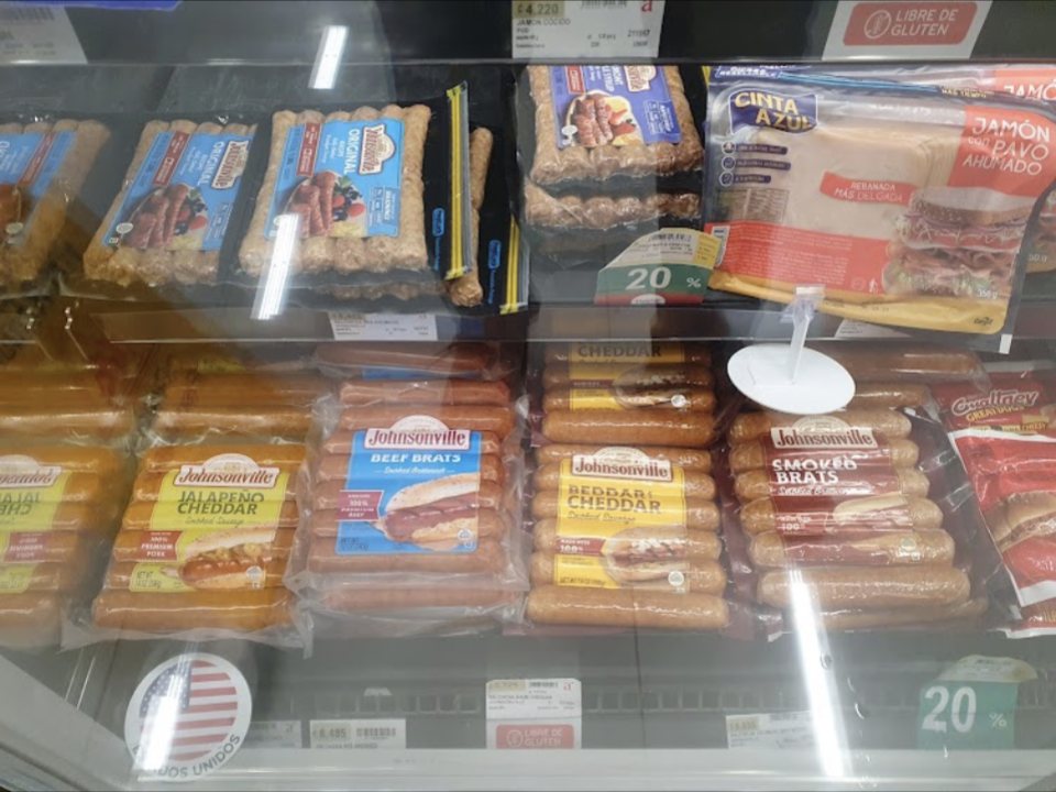 Packaged sausages and deli meats in the cooler at Auto Mercado in Herradura