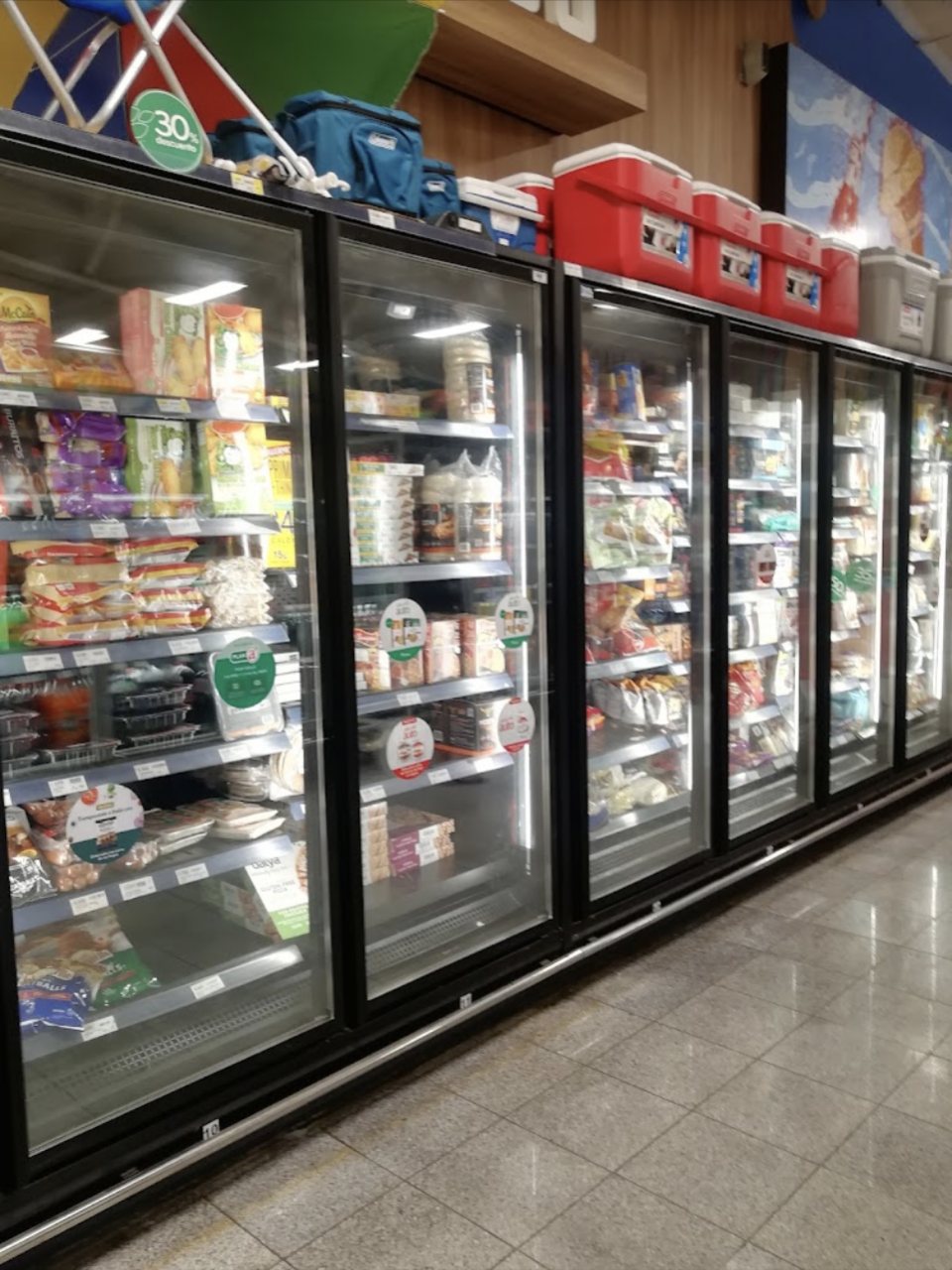 Long refrigerated and frozen grocery section at Auto Mercado in Herradura