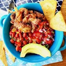 Chifrijo bowl with crispy chicharrón, red beans, avocado, and tostadas — classic Costa Rican bar food in Jaco