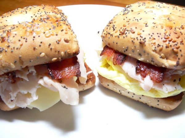 A toasted bagel breakfast sandwich with eggs, cheddar and bacon, cooked by a private chef in Jaco Beach