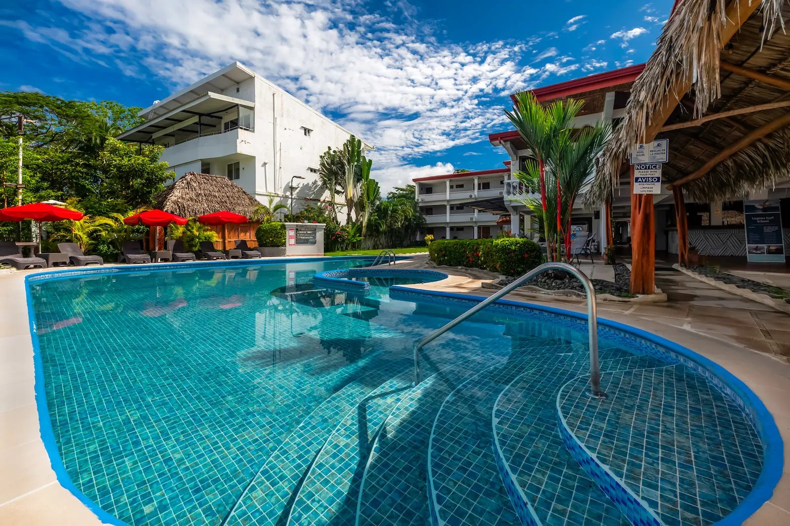 Private Resort & Beach Club — wide-angle pool with resort and Tiki palapa, South End Jacó Beach Costa Rica