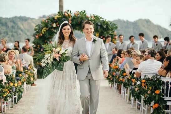 Wedding planning Jacó Beach — couple walking the aisle at beachside ceremony