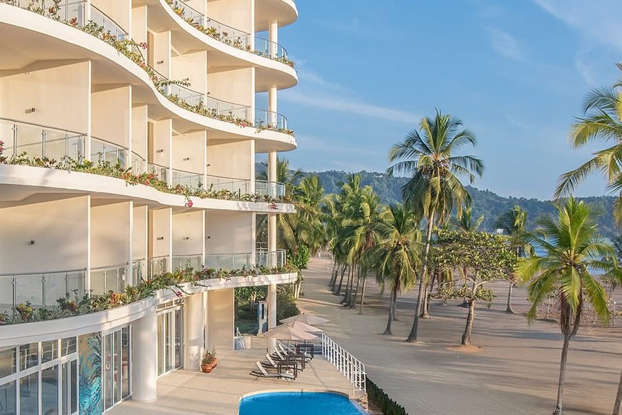 Clarita's beachfront resort building with its pool and palm-lined Jacó Beach sand