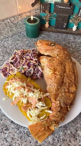 Whole pargo frito fried red snapper on a plate with patacones, coleslaw, and dipping sauce — a classic dish at Jaco Beach restaurants
