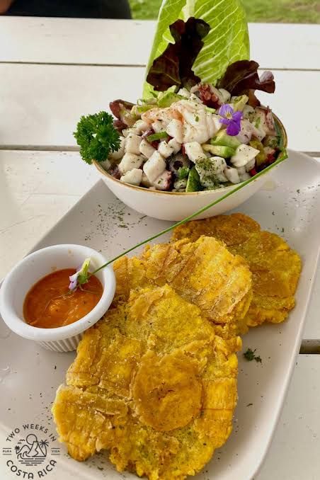 Fresh patacones served on a plate with dipping sauce alongside ceviche — a classic Costa Rican presentation at Jaco Beach restaurants