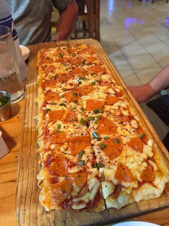A long meter-style pizza at Pizza Pata Jacó on the table