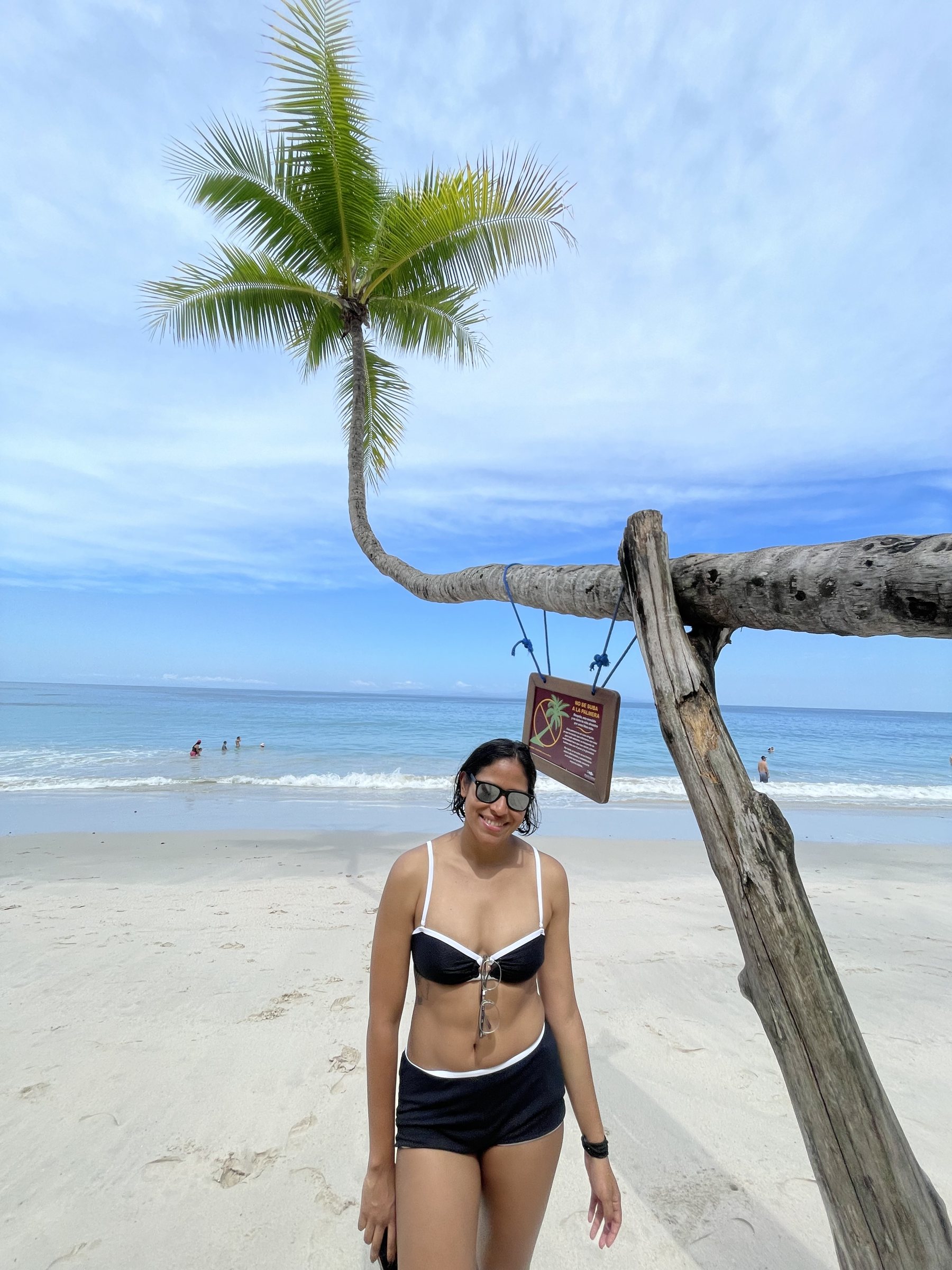 A leaning palm tree over the white sand at Playa Blanca beach in Punta Leona
