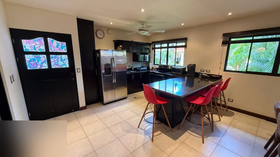 Modern kitchen with stainless appliances and stained glass door in the 2-bedroom villa at Punta Leona near Jaco Beach