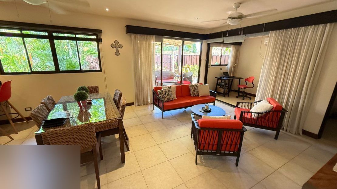 Living room with garden view and home-office space in the furnished Punta Leona villa — best priced real estate near Jaco