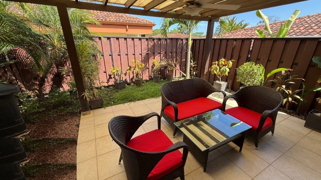 Private covered terrace with rattan seating and tropical garden at Villa Sitio de Ensueno — real estate Jaco area, gated community Punta Leona