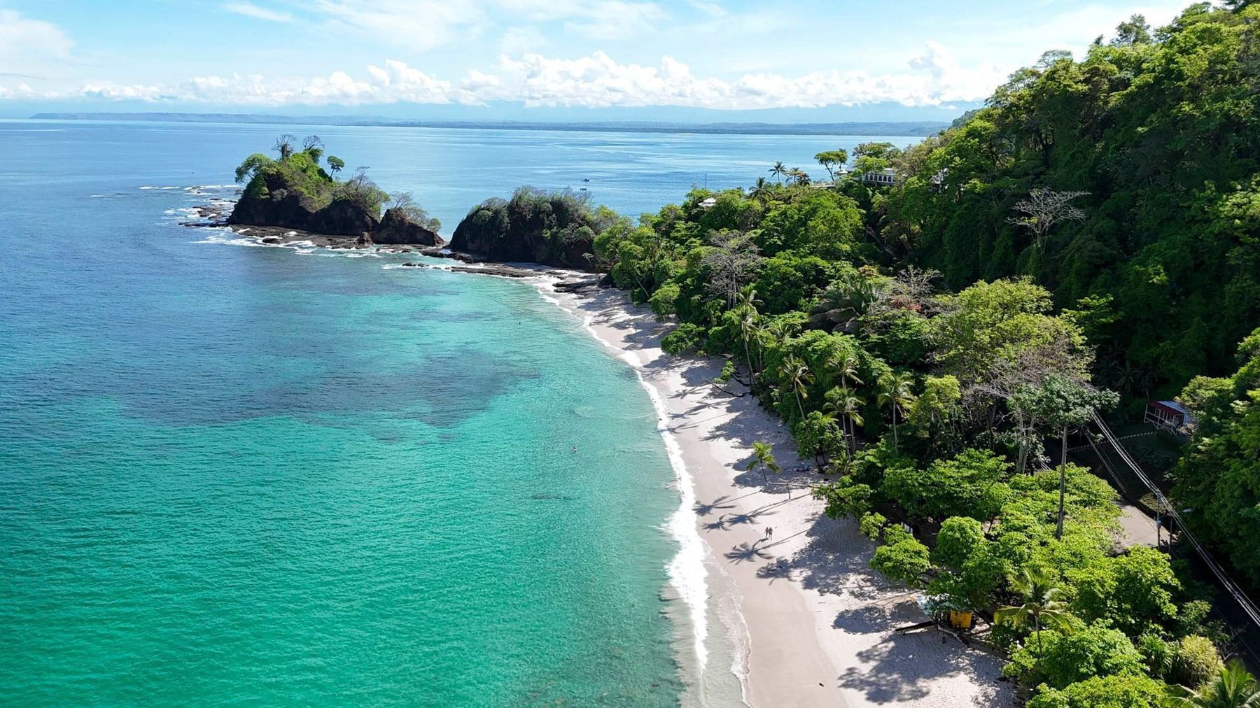 Aerial view of a white-sand cove and turquoise water at Punta Leona near Jacó