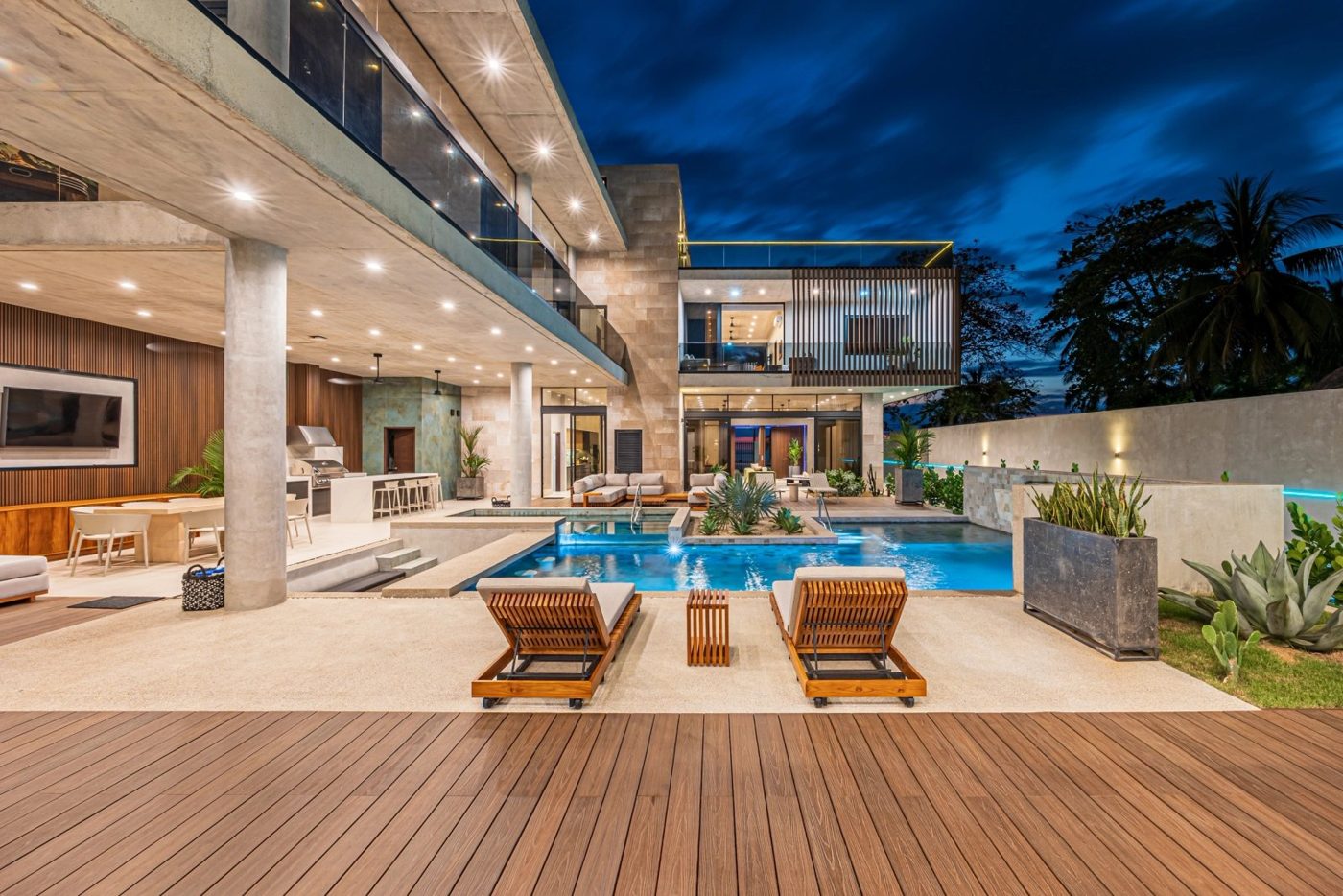 Casa VIP 1 luxury beachfront villa in Jacó — pool deck and villa lit up at dusk