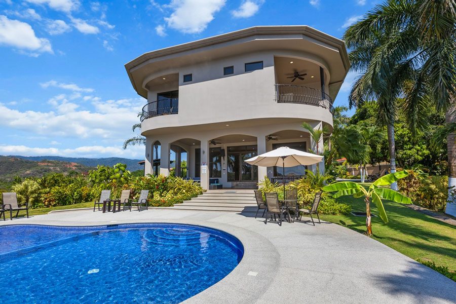 Casa VIP 10 — 10-suite jungle villa in Jacó, villa and curved pool from the garden