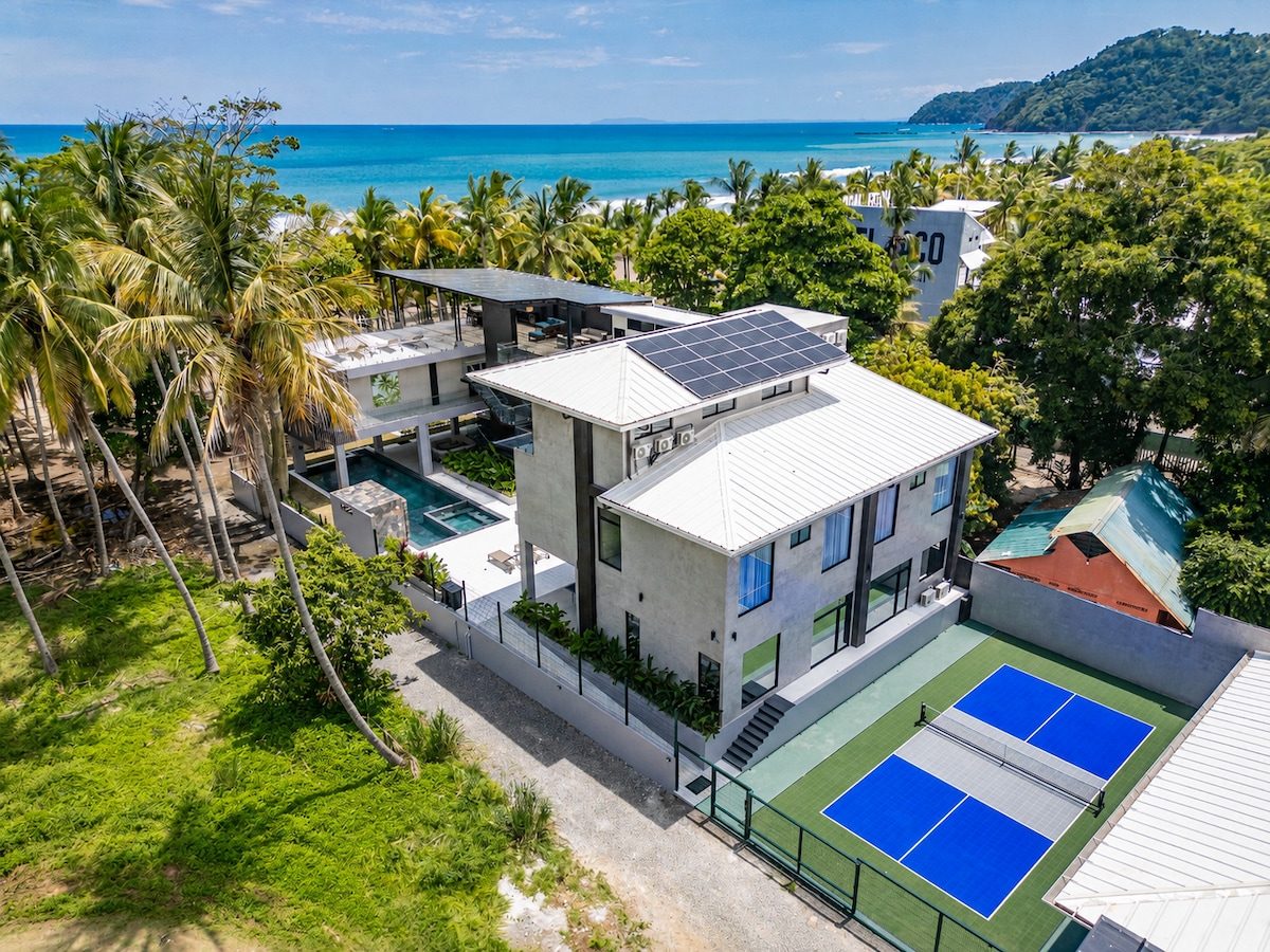 Casa VIP 2 — 15-bedroom beachfront estate in Jacó Beach, pool aerial through the palms