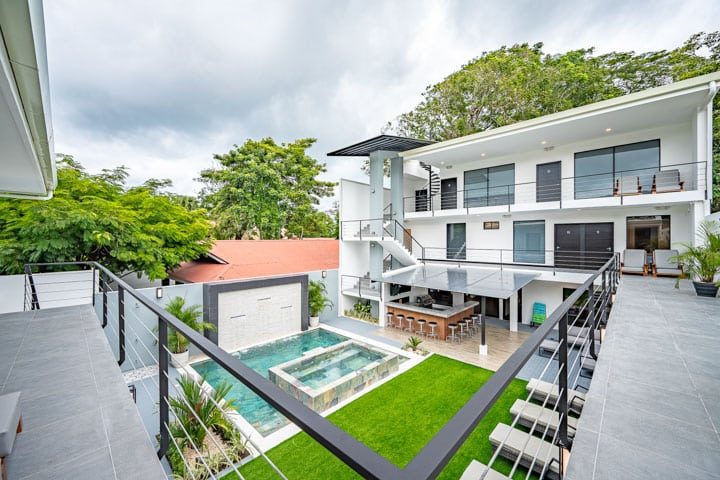 Casa VIP 5 — 13-bedroom beachfront villa in Jacó Beach, elevated view of the modern villa, pool and lawn