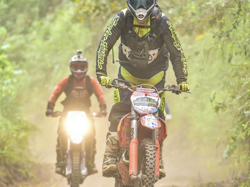 Dirt bike kicking up dust on a back-country road