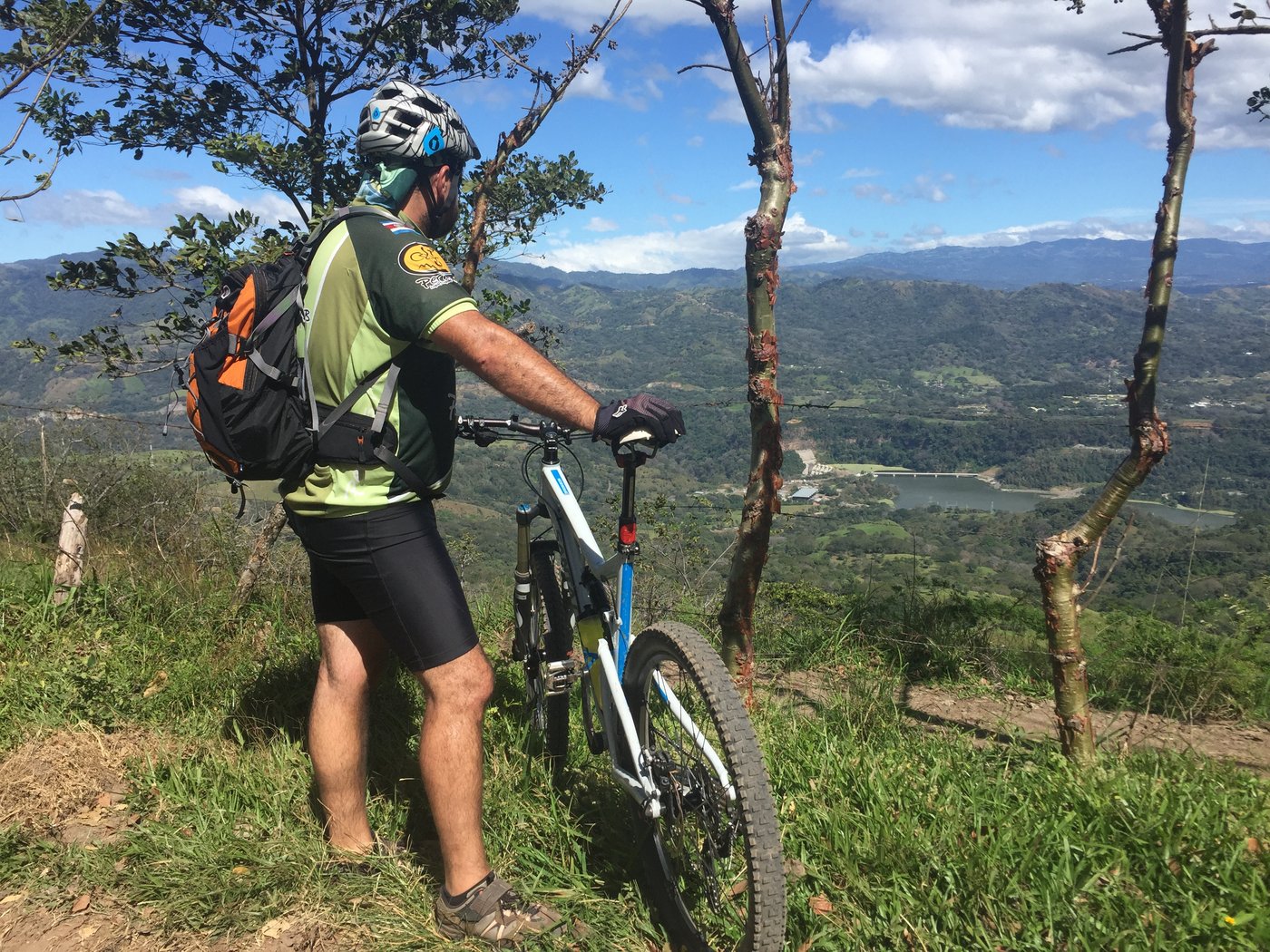 Mountain biker on a ridge overlooking a green valley