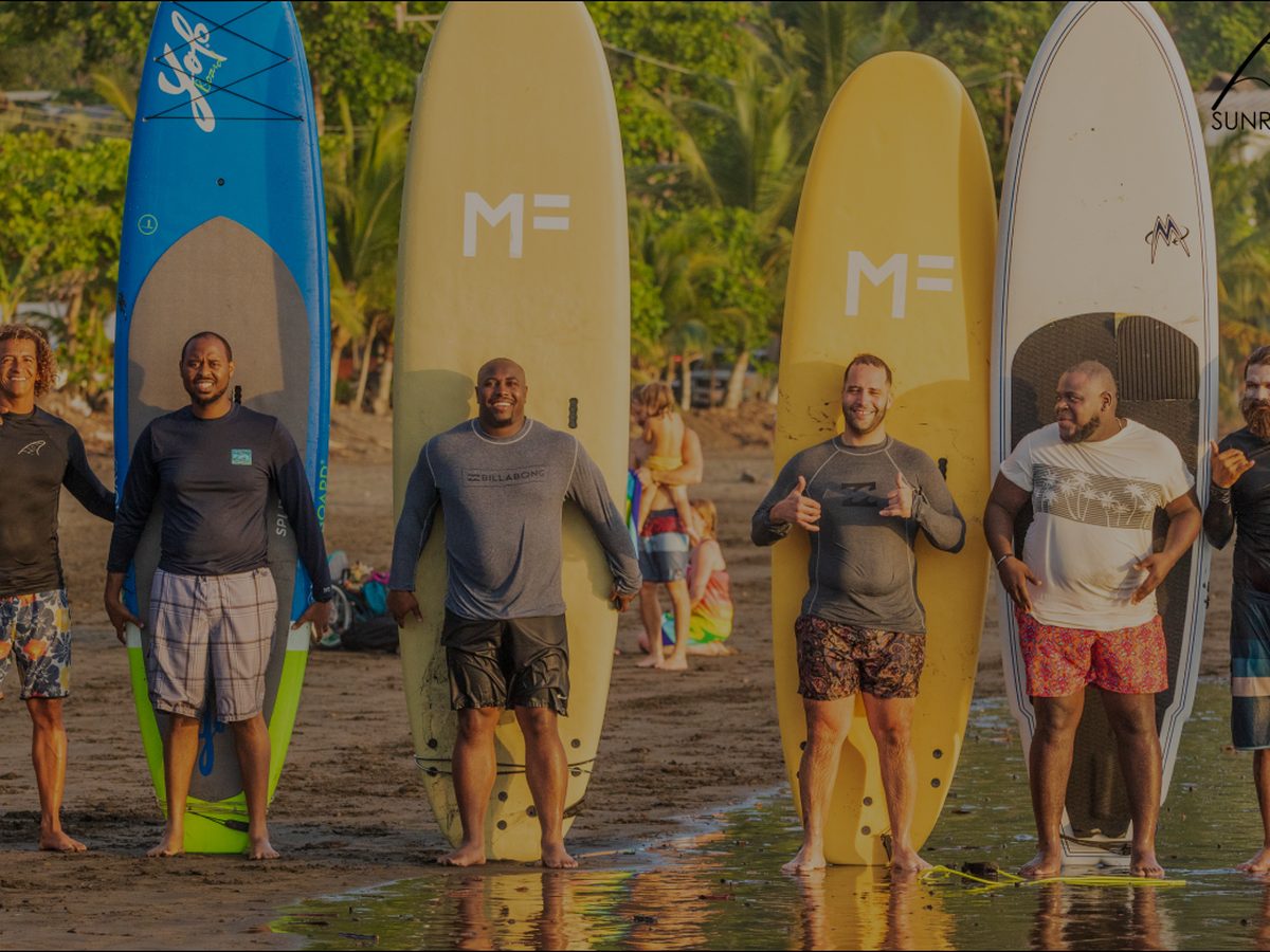 Surfboards lined up on the sand at Jacó Beach